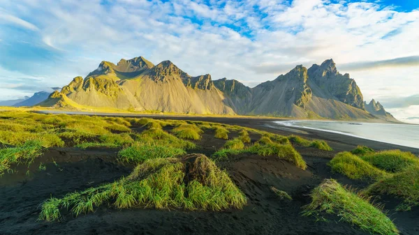 Vesturhorn Mountain in summer morning. Stokksnes, Iceland, Northern Europe, Scandinavia. Scenic beautiful nature landscape. Vibrant sunrise mountains landscape wallpaper. Popular tourist attraction.