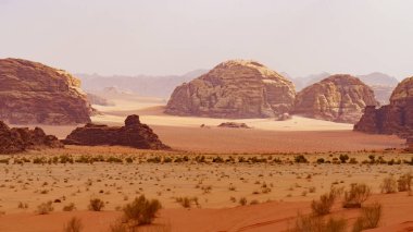 Wadi Rum çölü, Ürdün, Orta Doğu, Ay Vadisi. Turuncu kum, pus, bulutlar. Unesco Dünya Mirası Listesi'ne atılmıştır. Kızıl gezegen Mars manzarası. Offroad maceraları seyahat arka plan.