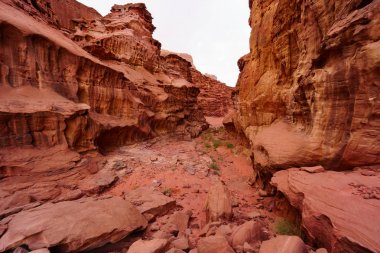 Wadi Rum çölündeki Kanyon, Ürdün, Orta Doğu, Ay Vadisi. Turuncu kum, pus, bulutlar. Unesco Dünya Mirası Listesi'ne atılmıştır. Kızıl gezegen Mars manzarası. Offroad maceraları seyahat arka plan.