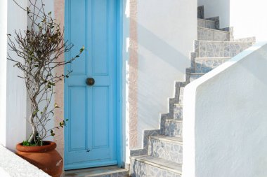 Santorini Adası açık mavi kapılar yakınında pota bitki, Kiklad, Yunanistan. Konut beyaz duvarlar evin geleneksel tasarımı.