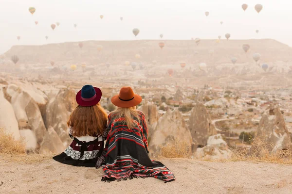 カッパドキア渓谷の空に空気のバロンを見て本物のボーホシックなスタイルのポンチョ 甘いと帽子を身に着けている旅行女性 旅行と放浪の概念 スペースの背景をコピーする — ストック写真