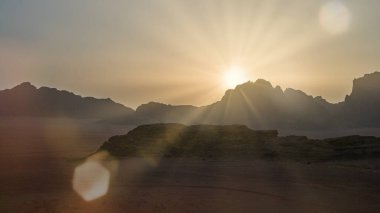 Canlı bir gün doğumu, engebeli dağların üzerine, manzaranın doğal güzelliğini gösteren sıcak bir ışık yayar. Sahne, çevrenin korunması ve sürdürülebilirliği hakkında iyimserliği çağrıştırıyor..