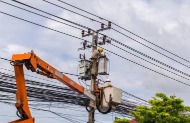 Elektrikçi elektrik direği üzerinde çalışıyor. Kullanım vinç yüksek gerilim