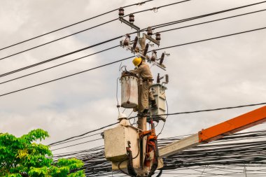 Elektrikçi elektrik direği üzerinde çalışıyor. yüksek gerilim tarafından Stapler sepet kullanın.
