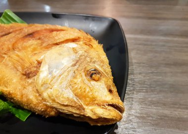 Tabakta kızartılmış balık yemeye hazır ve masada biber sosu