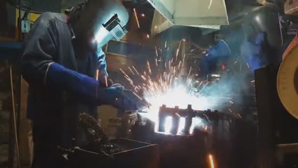 工場産業で自動車部品を溶接する2人の従業員 — ストック動画