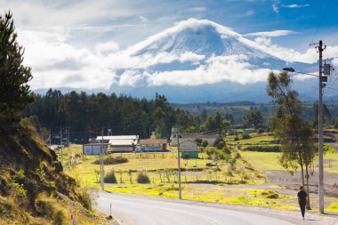 Cotopaxi Ekvador Mayıs 2018 gündoğumu Ulusal parka giden yol boyunca, bir kişi yürüyor ve arka planda kar yanardağ şapkalı.