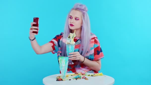 Cute girl taking pictures of her freakshake and taking selfies — Stock Video