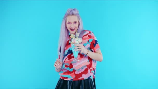 Chica bailando con freakshake sobre fondo azul — Vídeo de stock