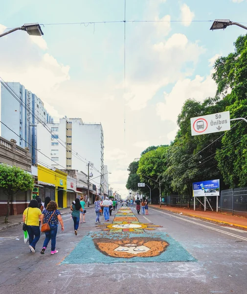 Campo Grande, Brezilya - 31 Mayıs 2018: Corpus Christi olay 14 de Julho Street tatil. İnsanlar ile Hıristiyan sanat ve haber sokak katta talaş yapımı halı, el işi.