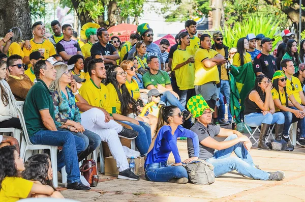 Campo Grande, Brezilya - 17 Haziran 2018: Praça oturmuş insanlar radyo Clube Meydanı izlemek ve bir eşleşme 2018 Dünya Kupası'nda Brezilya ekibinden tezahürat yapar.