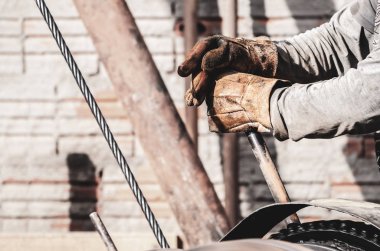 Çalışan bir şahmerdan (bate-estaca) kolu çekerek eller. İnşaat işçisi. İki el bir kolu tutan. Bir motor tetikleme eldiven yıpranmış giyen işçi eller hamle o çelik kablolar.