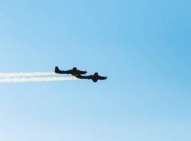Birlikte geride bırakarak duman izi uçan iki uçak silueti. Hava akrobasi uçak. A-29 Super Tucano uçak. Metin üzerinde sky için yer.