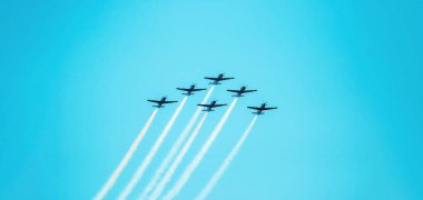 Kadrosu altı uçak uçan birlikte gökyüzüne üzerinde gidiş arkasında duman bir iz bırakıyor. Hava akrobasi uçak. Açık mavi gökyüzü gün. A-29 Super Tucano uçak. 