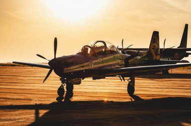 Campo Grande, Brazil - September 09, 2018: Esquadrilha da Fumaca airplane (FAB) landed at the Air Base after the air show presentation, photo at sunset. A-29 Super Tucano plane.  clipart
