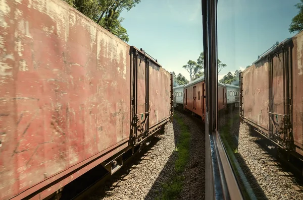 Parked wagons of two trains side by side, each one on his railway. Corridor between two trains.