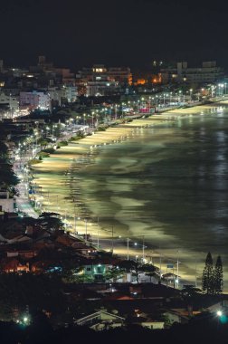 Bombinhas - Sc, Brezilya - 18 Aralık 2018: geceleri görünümü Praia de Bombas ve Bombinhas şehir. Turizm sezonu, şehir bina, ana cadde Leopoldo Zarling ve Bombas beach.