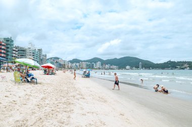 Itapema - Sc, Brezilya - 26 Aralık 2018: Meia Praia Itapema Plajı'nda insanlar. Yüksek sezonunda, yıkananlara önünde denizin, kumun üzerinde güzel yaz günü turistik plaj.