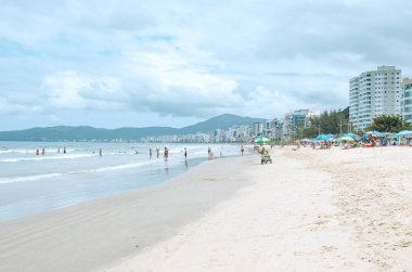 Itapema - Sc, Brezilya - 26 Aralık 2018: Meia Praia Itapema Plajı'nda insanlar. Yüksek sezonunda, yıkananlara önünde denizin, kumun üzerinde güzel yaz günü turistik plaj.