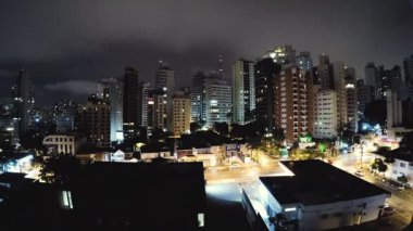 Geceleri Sao Paulo'nun timelapse videosu. Bulutlu bir gecede Sao Paulo şehrinin binaları. Bulutlar hızlı hareket ediyor. Aclimacao yerleşim mahalle, şehrin merkezi alan.