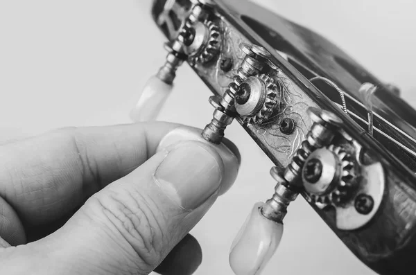 Tuning an old acoustic guitar — Stock Photo, Image