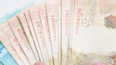 Bir el fan gibi Brezilya gerçek banknotlar sürgülü. 50 ve 100 reais brl. Brezilya parası, gerçek banknotlar. Eller kayan para faturaları.