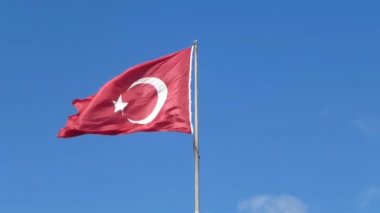 Rüzgara karşı mavi gökyüzü içinde çırpınan Türkiye'nin bayrak.