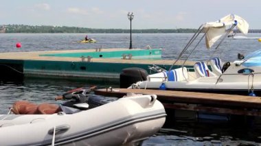 Tekneler jet ski yarışın başlamasından uzaktan gördüğümüz dalgalar üzerinde sallanan iskelede duruyorsun.
