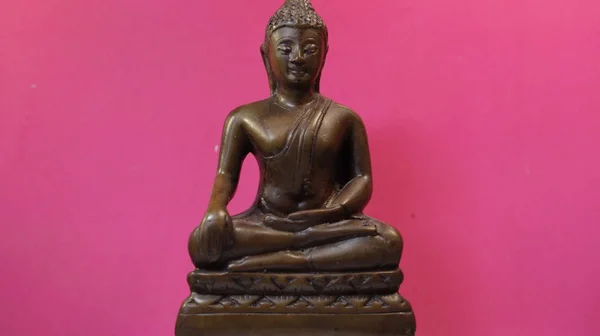 Pembe arka planda Buda, insanlar ve yüce güçler arasında bir arabulucunun sembolü..