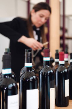 kadın sommelier arka planda kırmızı dolcetto şarap bir şişe uncorking