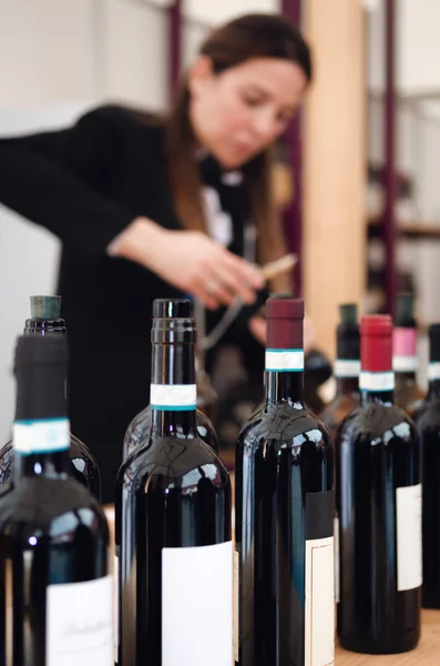 Жіночий сомельє розстебнувши пляшку червоного дельцетового вина на фоні — стокове фото
