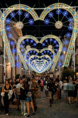 Cuneo Illuminata sırasında geceleri ışık ve müzik performansı altında yürüyen kalabalık