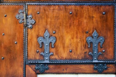 Floransa, İtalya 'daki Ponte Vecchio' nun üzerindeki geleneksel bir Toskana dükkanının kapısında antik metal menteşeleri olan sade, eski kırmızı ahşap bir yüzey.