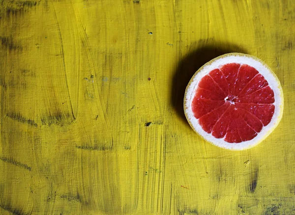 red grapefruit on yellow background top view