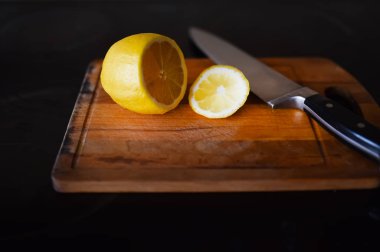bir kesme tahtası bir bıçakla kesilmiş limon