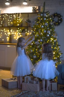 Çocuklar Noel ağacını süslüyor.