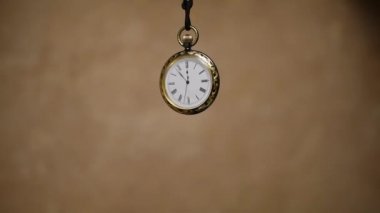 sallanan bir sarkaç gibi bir kablosunun üzerine askıya vintage cep saati