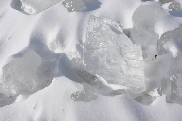 pieces of transparent ice on white snow