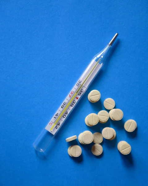 Merkür termometre ve mavi renkli hapları