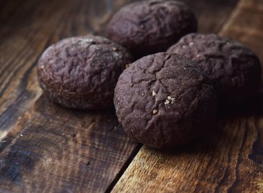 ahşap bir masa üzerinde kimyon ile kahverengi çavdar çörekler