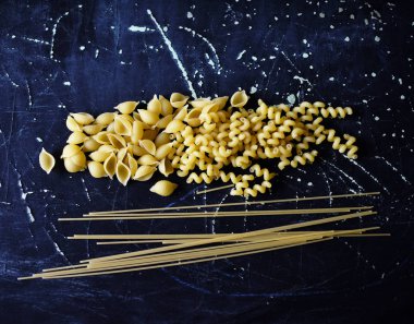 Koyu arkaplanda farklı şekillerde makarna