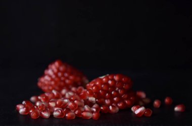 Siyah arkaplanda kırmızı nar tohumları