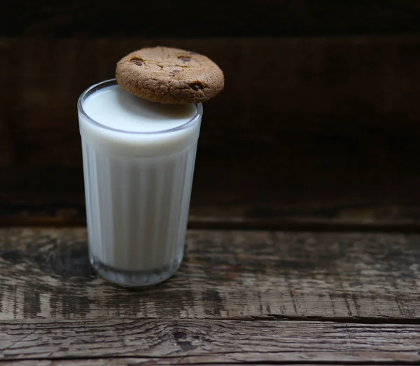 木の板の上にチョコチップをかけたミルククッキーのガラス — ストック写真