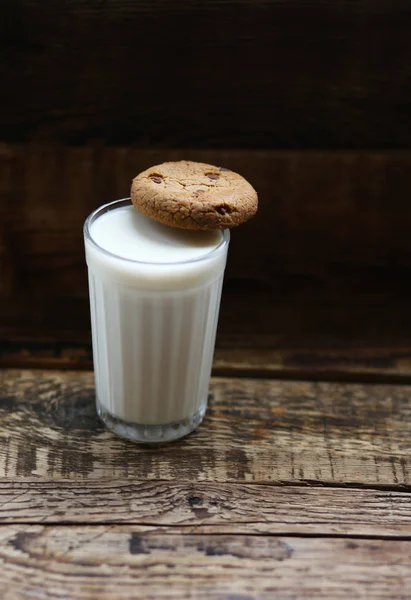 木の板の上にチョコチップをかけたミルククッキーのガラス — ストック写真