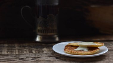 Krepler, bir bardak tutacağında yoğunlaştırılmış sütlü siyah çay.