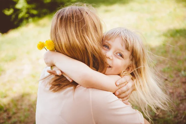 Mutlu küçük kız annesi sarılma güneşli gün ve gülümseme, Aile hayatı