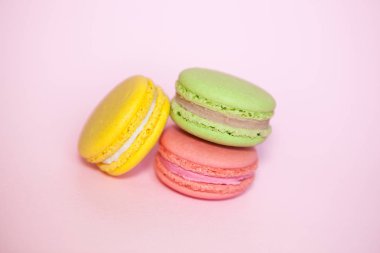 Pembe ynd sarı ve yeşil acıbadem kurabiyesi bisküvi pastel arka plan üzerinde Fransız