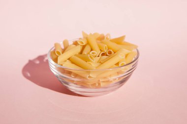 İtalyan makarna kase kavramı pişirme pembe arka plan üzerinde