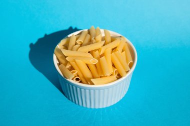 Mavi arka plan, gıda kavramı üzerinde bir kapta makarna