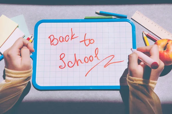 Back to school, hand write text on blackboard with apple on table as education concept